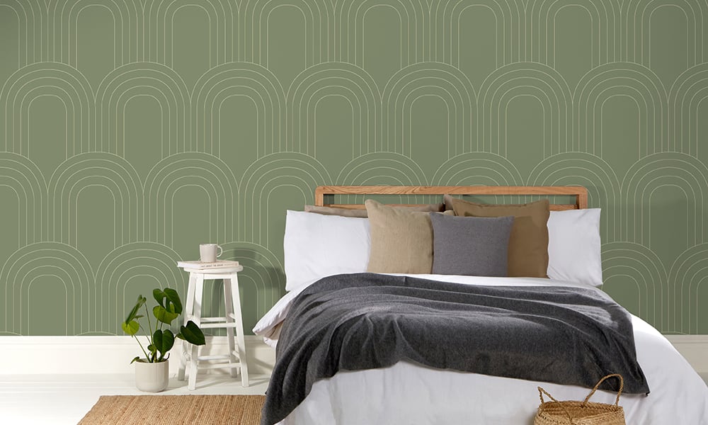 Large-scale retro loop patterned wallpaper in olive green in a bedroom setting