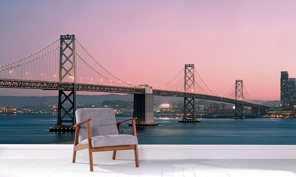 Sunset wall mural with San Francisco Bridge in a lounge with a grey chair