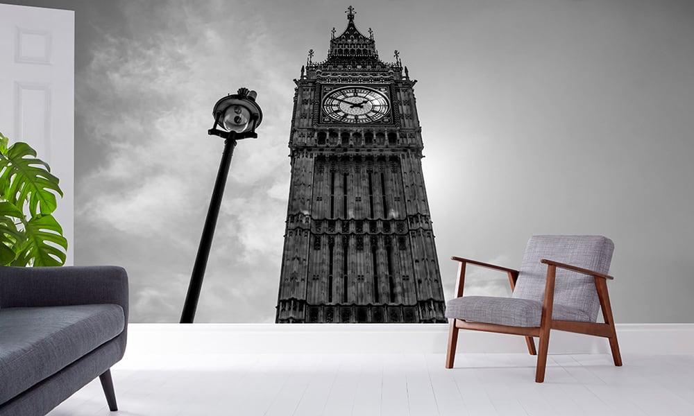 Big Ben wallpaper in monochrome in a living room setting with a grey chair and white floor