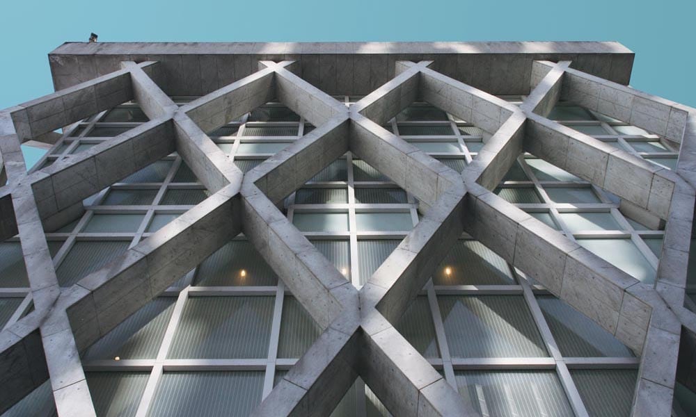 Concrete brutalist building with diamond shaped features from a low angle