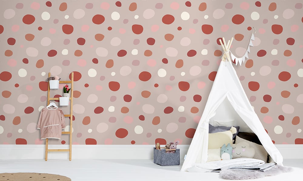 Playful pink spot print wallpaper in a large size pattern in a kid's bedroom
