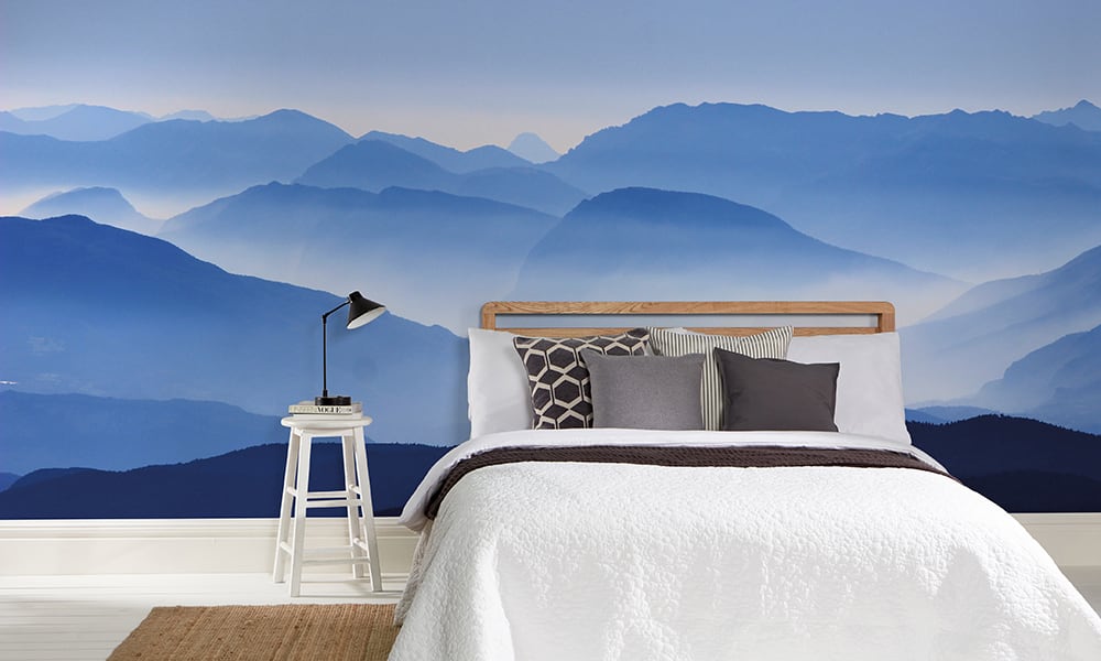 Mountain range wall mural in blue tones in a bedroom setting
