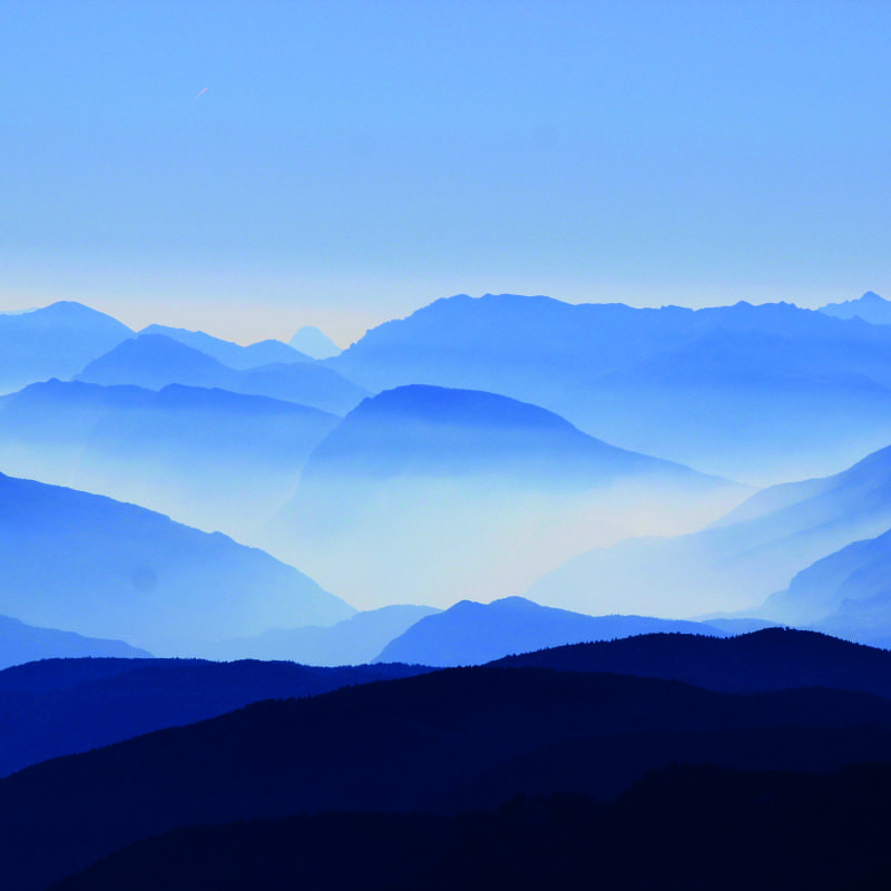 Bedroom scene with blue moutain range wall mural