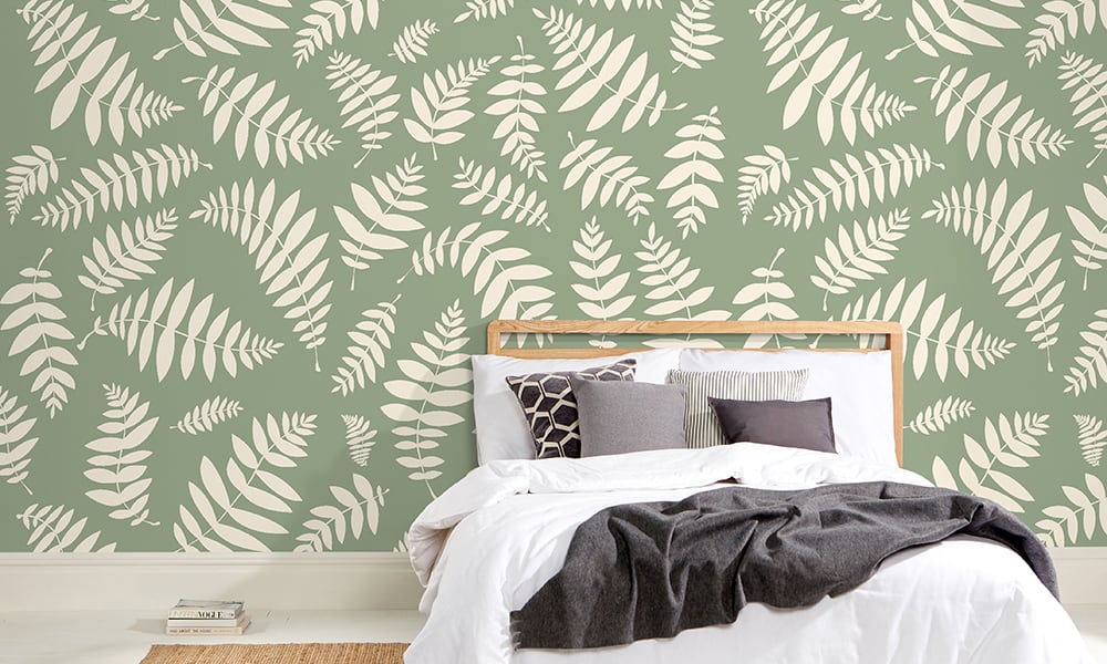 Green large-scale leafy wallpaper design in a minimalist bedroom  