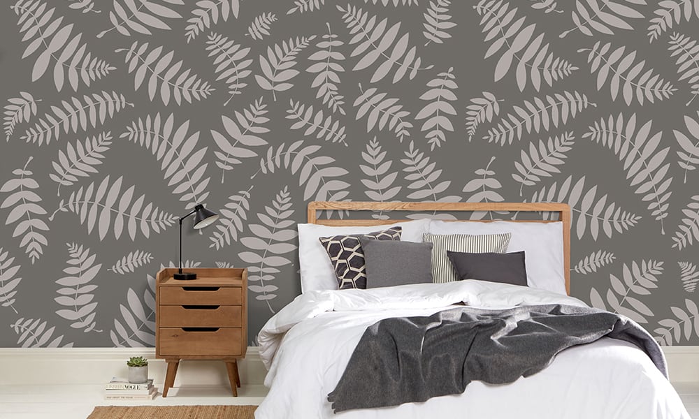 Grey leafy nature-themed wallpaper in a large-scale pattern in a bedroom setting