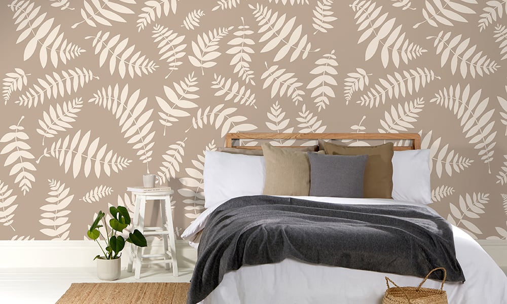 Taupe leaf large-scale wallpaper pattern in a scandi bedroom setting with plant