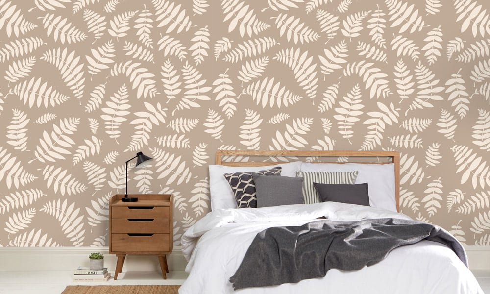Nature-themed leafy wallpaper pattern in neutral taupe colour in a bedroom  