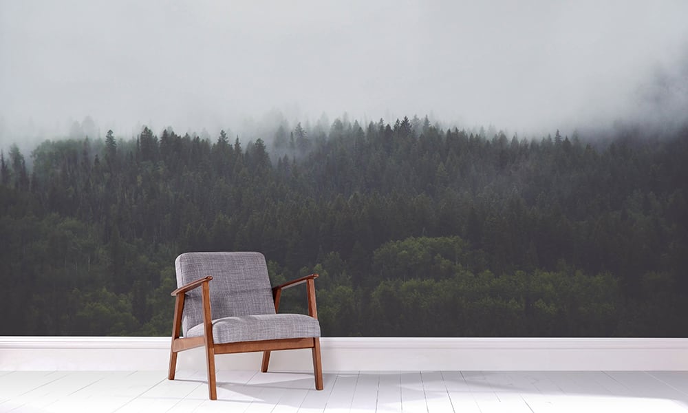 Forest wallpaper in a living room with grey chair