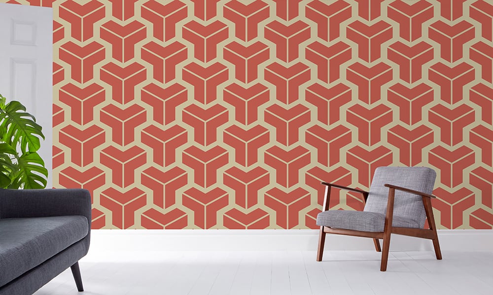 Bold geometric terracotta orange wallpaper design in a large-sized pattern with a grey chair