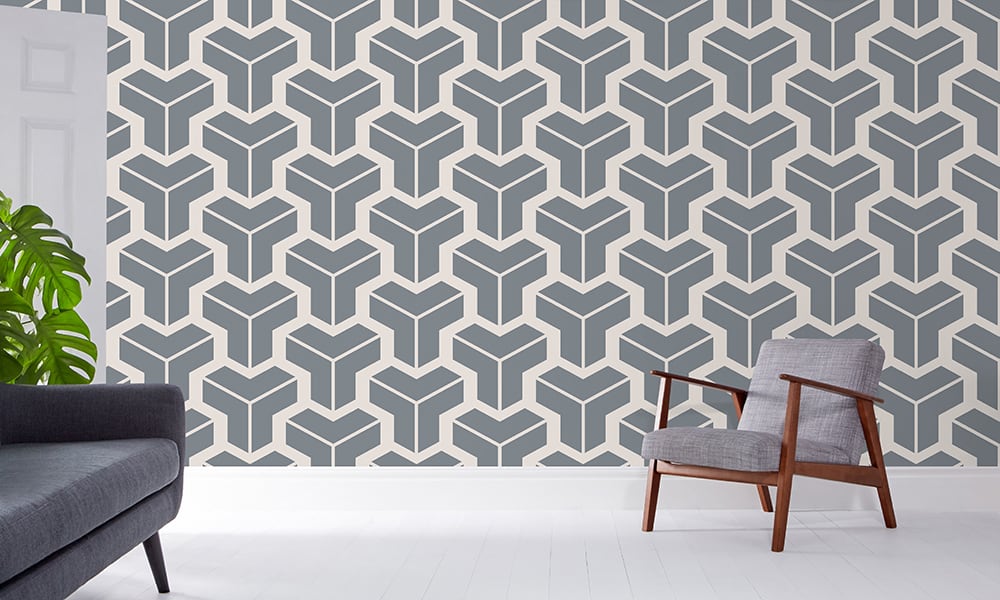 Modern geometric steel blue-grey wallpaper in a large pattern in a living room with grey chair