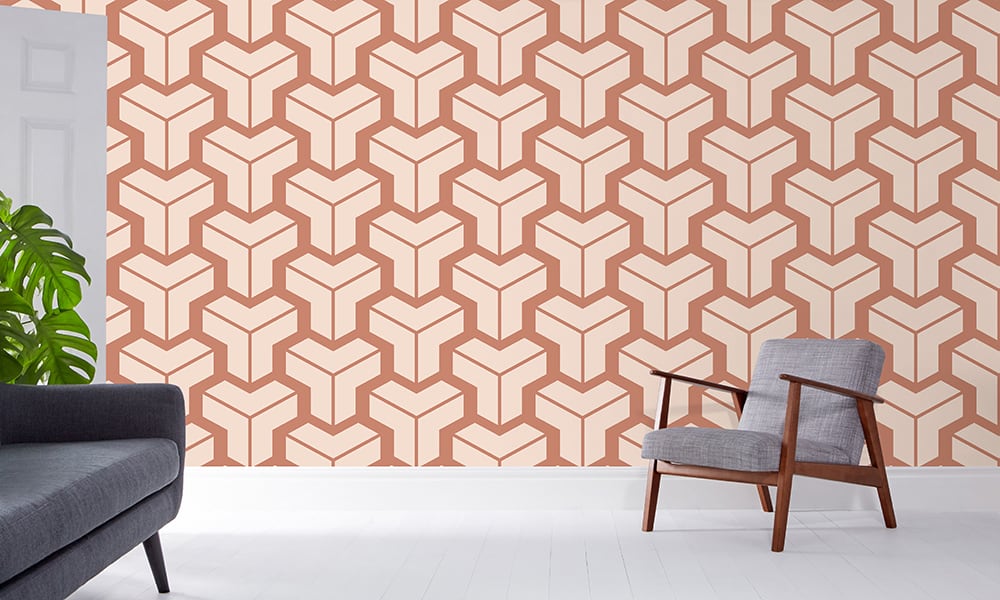 Terracotta geometric neutral wallpaper in a large pattern in a lounge with grey chair