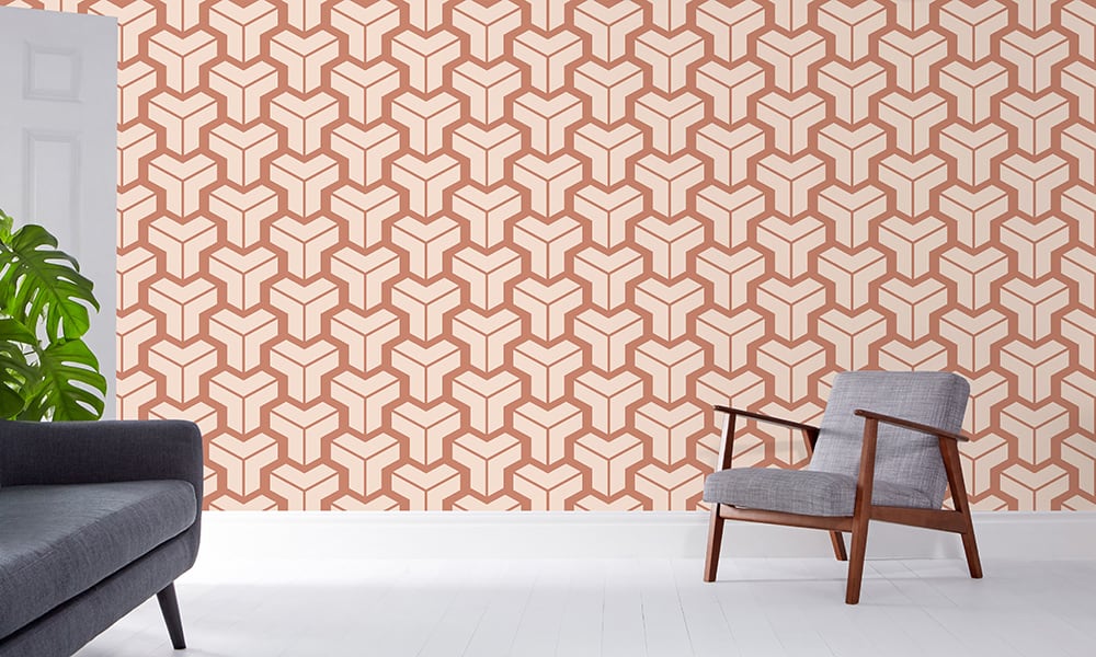 Orange and neutral geometric wallpaper in a medium-sized pattern in a living room with grey chair