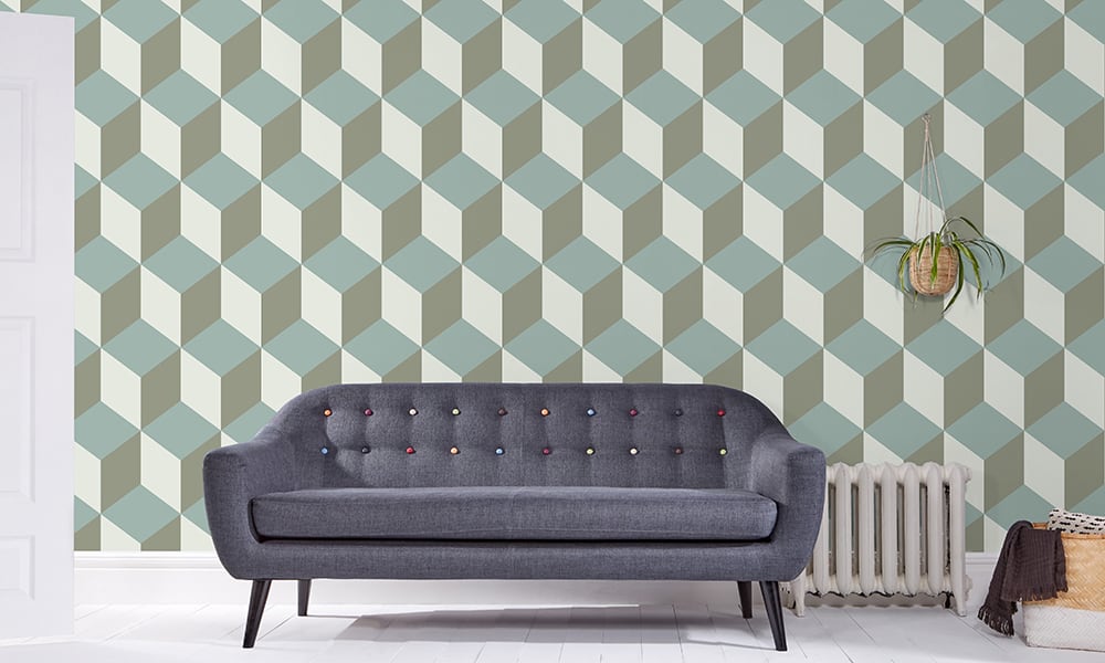 Large scale cube-shaped wallpaper pattern in sage green tones in a living room