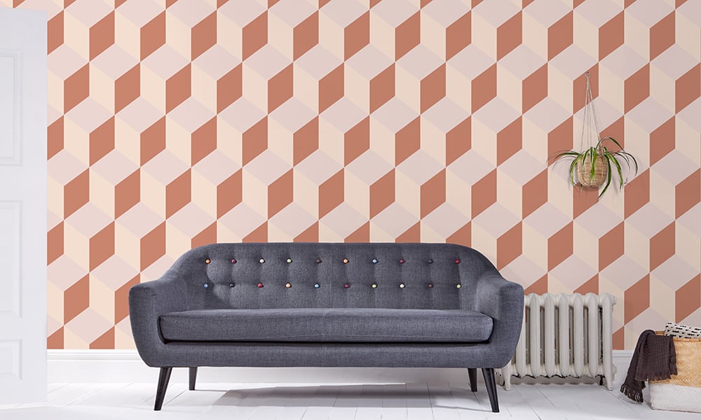 Large scale cube-shaped wallpaper design in orange and pastel colour tones in a living room