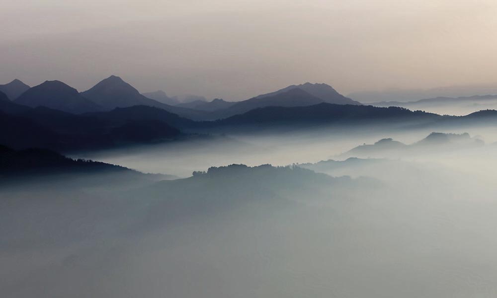 Misty moutain landscape with dark grey and pastel sky