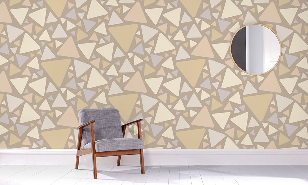 Large-scale triangular design in neutral colour tones in a living space with a grey chair