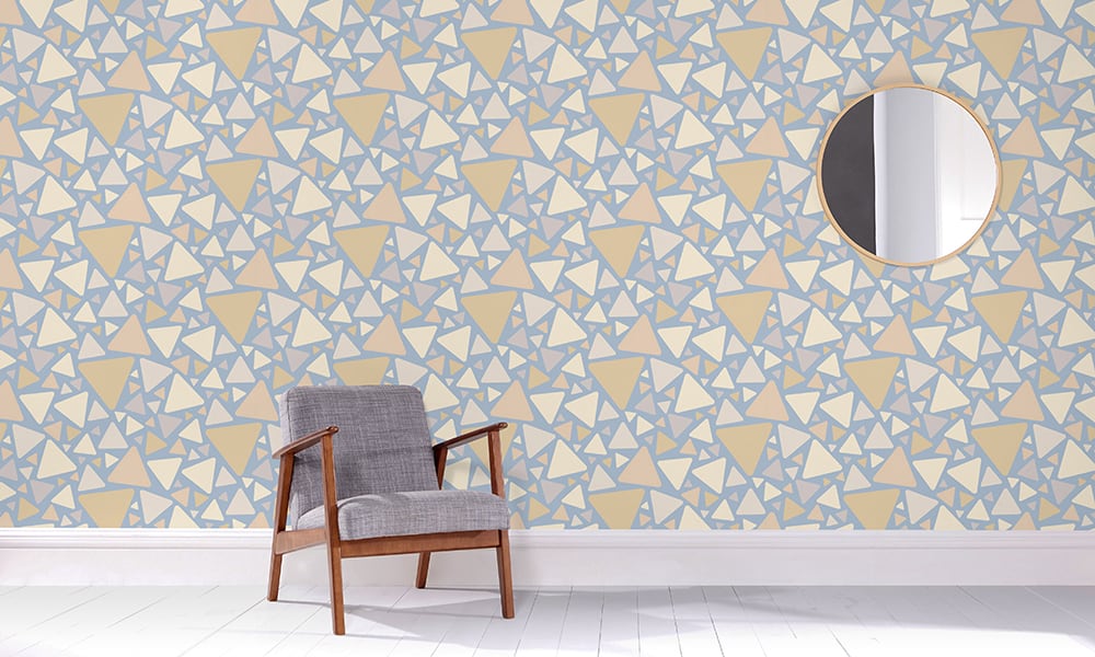 Medium-sized triangular pattern in a blue and neutral colour palette in a living room with grey chair
