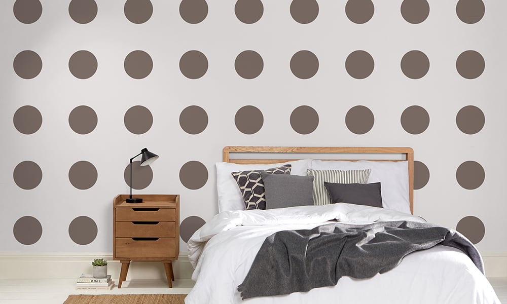 Large-scale polka dot pattern in a grey and brown colour in a bedroom