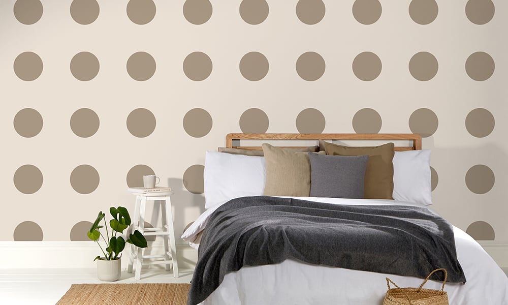 Large-scale polka dot pattern in a neutral taupe colour in a bedroom
