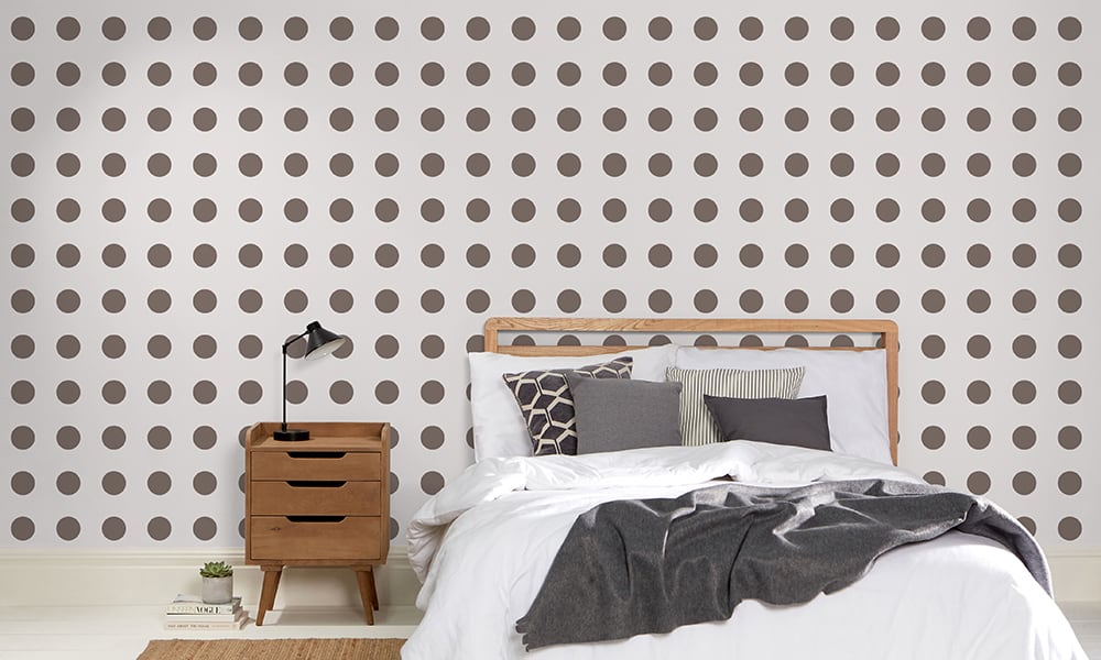 Grey and dark brown polka dot in a pattern in a bedroom setting
