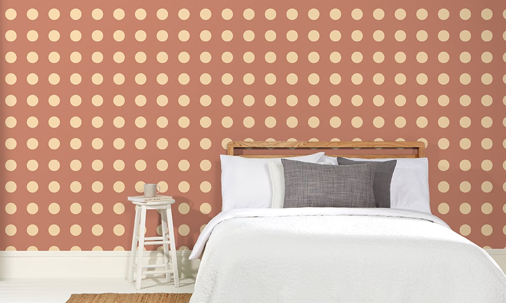 Terracotta orange polka dot wallpaper in a medium-sized print in a bedroom