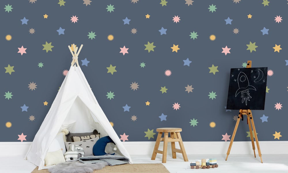 Large-scale navy blue wallpaper with pastel coloured stars in a child's bedroom