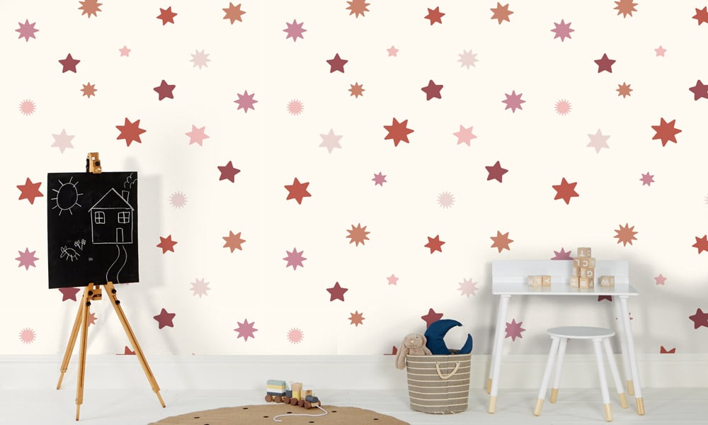 Large-scale star wallpaper with red and pink stars and a light background in a kid's bedroom