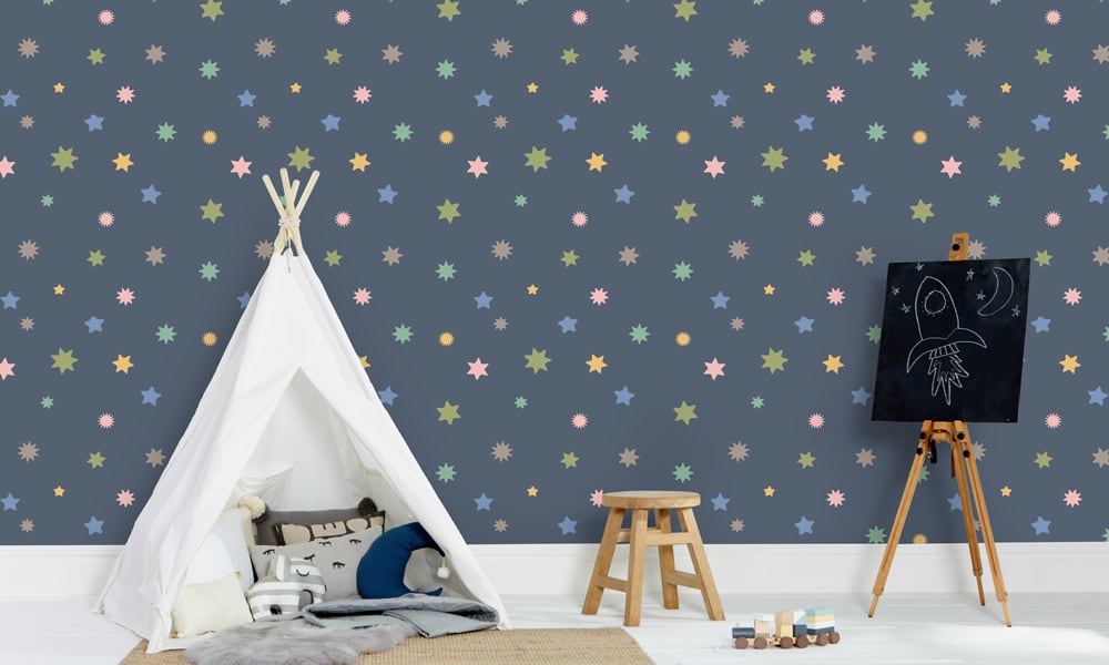Navy blue wallpaper with pastel coloured stars in a kid's bedroom