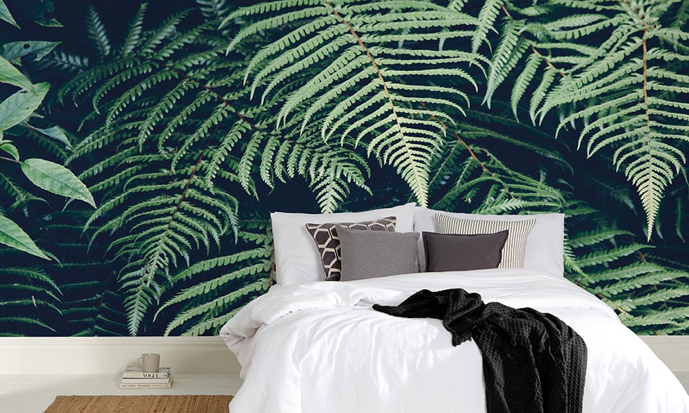 Green leafy bracken nature wall mural in a minimal scandi bedroom   