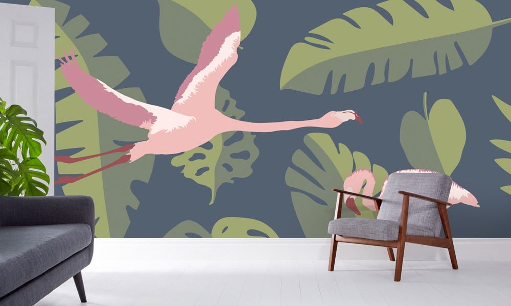 Navy pink and green flamingo themed wall mural in a living room with grey chair and sofa