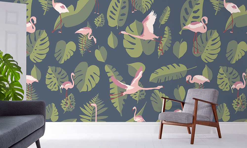 Large-scale pink flamingo wallpaper with a navy background and green leaves in a living room