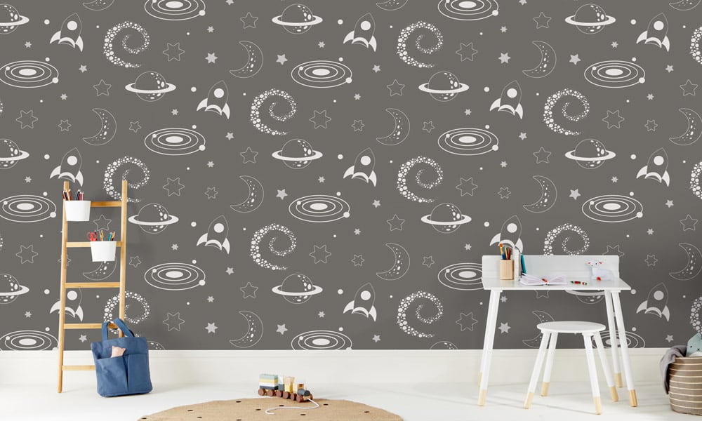 Grey space-themed wallpaper with rockets, stars and moons in a kid's bedroom 