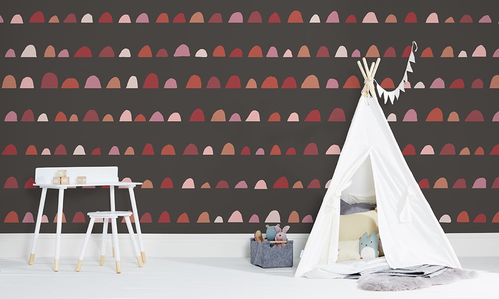 Children's wallpaper with dark grey background and large-scale red and pink humps pattern 