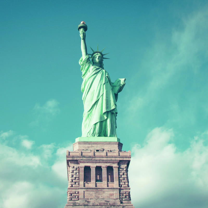 Statue of Liberty wall mural in a living room with grey chair