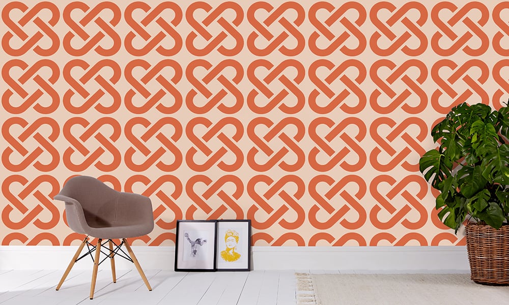 Large scale linked wallpaper in orange with grey chair and frame