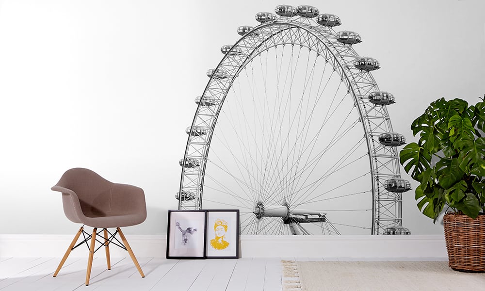 Black and white London eye wallpaper in living room with grey chair