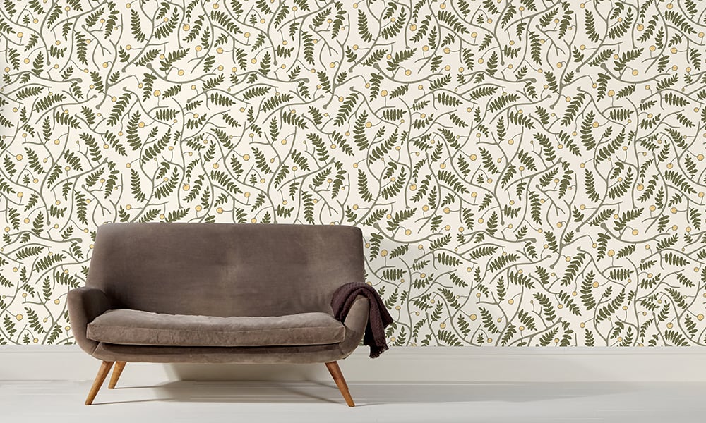 Green wallpaper in a medium scale situated in living room with grey sofa 