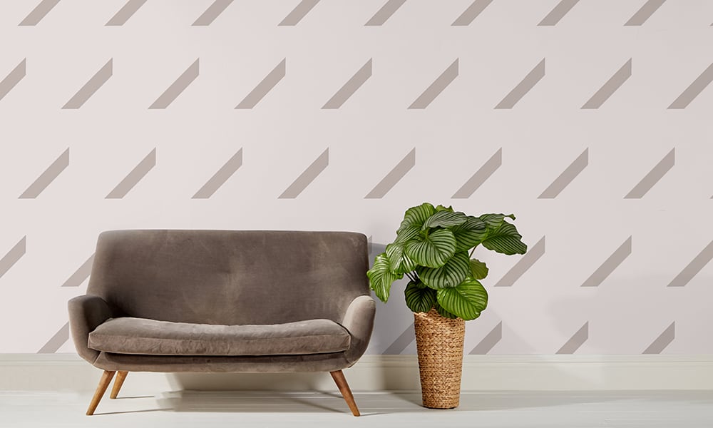Large scale oyster repeat pattern wallpaper with grey sofa and plant
