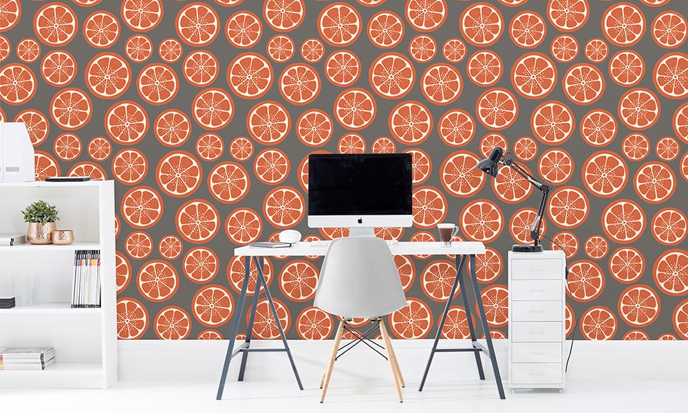 Sliced orange wallpaper design in medium scale with grey background and desk and chair