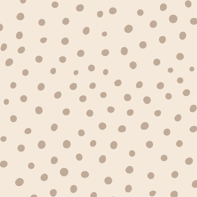 Neutral polka dot wallpaper situated in kids bedroom with a chalk board