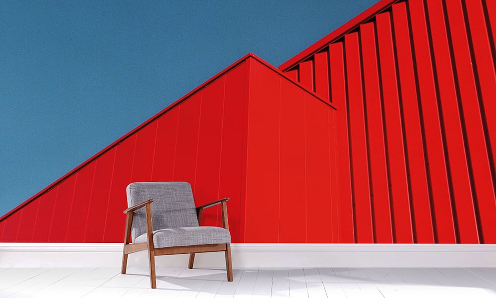 Bright red building architectural wall mural with blue sky in a living room