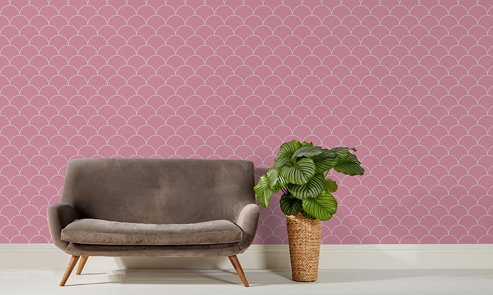 Scales wallpaper design in pink and a medium size with grey sofa and plant