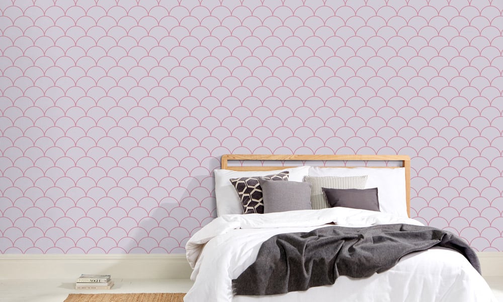 Scales wallpaper design in heather and a medium size with grey cushions and book