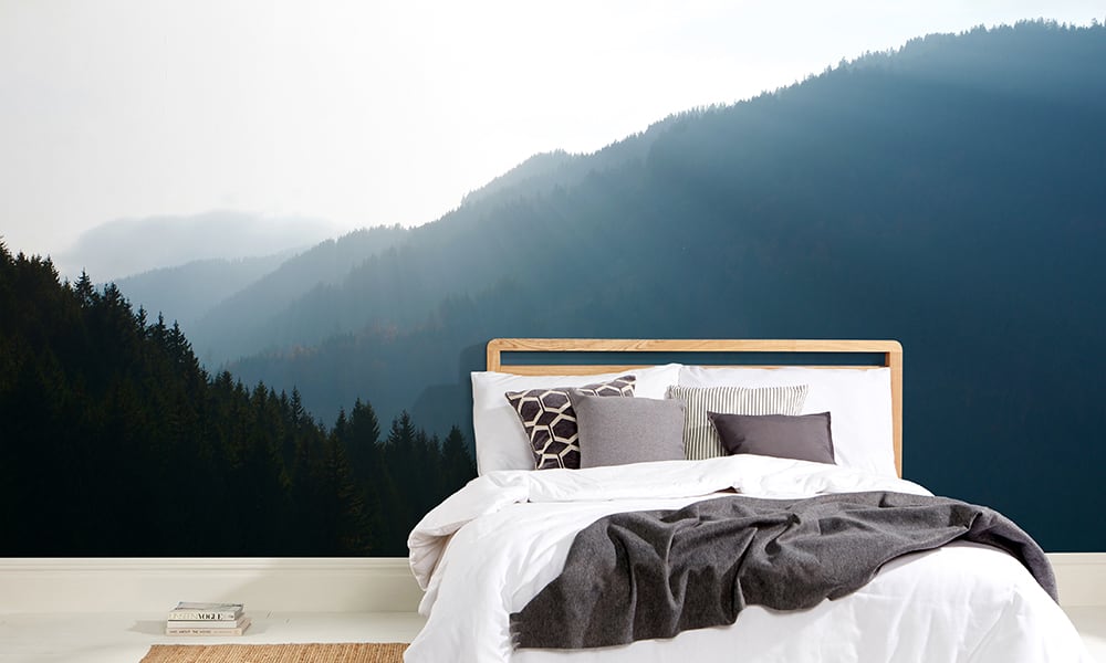 Scandinavian bedroom with forest fir tree wall mural behind bed