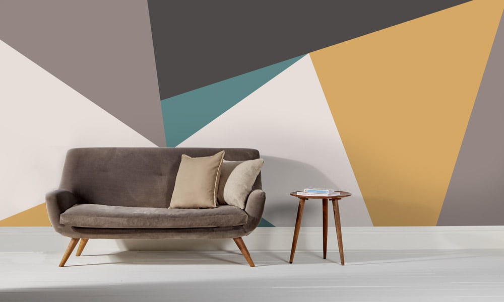Grey, yellow and teal wall mural with clean lines in a modern lounge with mid-century style sofa