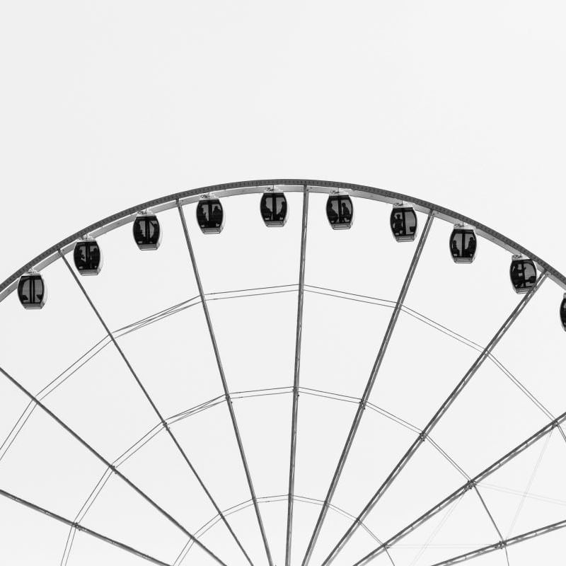 Modern monochrome wallpaper of a ferris wheel in a living room setting with grey chair