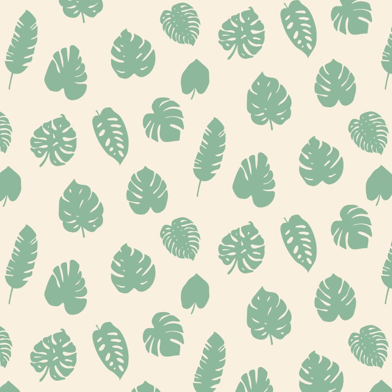 Green leafy patterned wallpaper in living room with grey chair and frames