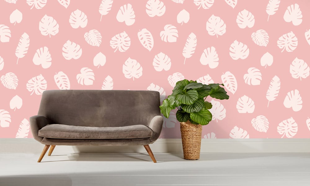 Large scale wallpaper pink leaves with sofa and cheese plant