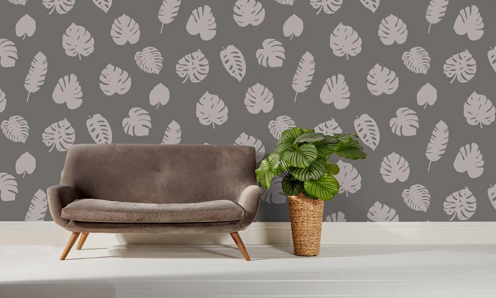 Large scale wallpaper grey leaves with sofa and cheese plant