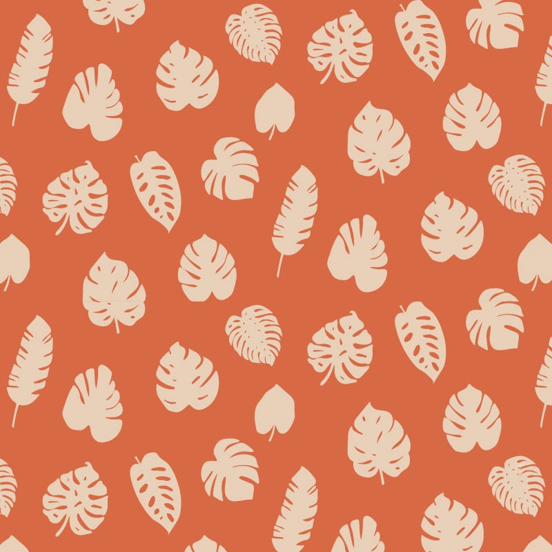 Orange leafy patterned wallpaper in living room with grey sofa and cheese plant